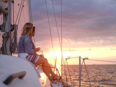Couple of cheerful girls are enjoying their trip on yacht