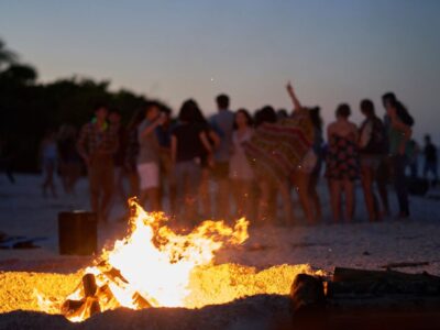 30 San Juan bonfire celebration on an Ibiza beach with people dancing at sunset