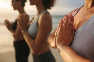 People practicing yoga on a peaceful Ibiza beach at sunrise
