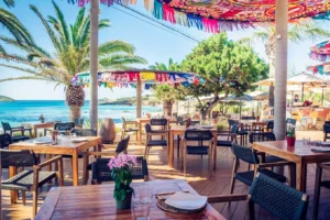 Eco-friendly beach club Aiyanna with colorful umbrellas in Cala Nova, Ibiza