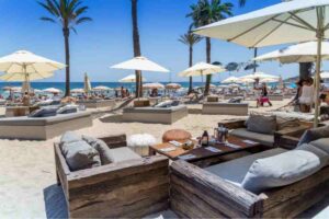 Boho-chic setting at Beachouse Ibiza with beachfront tables and palm trees