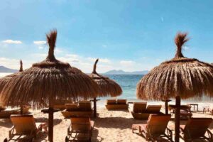 Children playing near loungers at Tropicana beach club in Cala Jondal, Ibiza