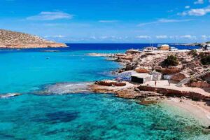 Cala Bassa is known for its crystal-clear water, gentle waves, and vibrant atmosphere—perfect for families, paddleboarding, or lounging at the Cala Bassa Beach Club.