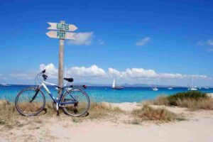 Tourist renting a bike to explore Formentera beaches near Ses Illetes