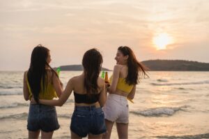  A group of women smiling at a beach club during sunset