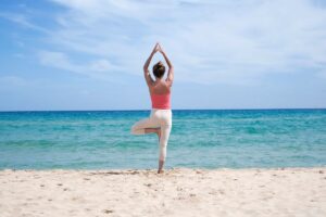 Solo female traveler practicing yoga at a peaceful beach in Ibiza