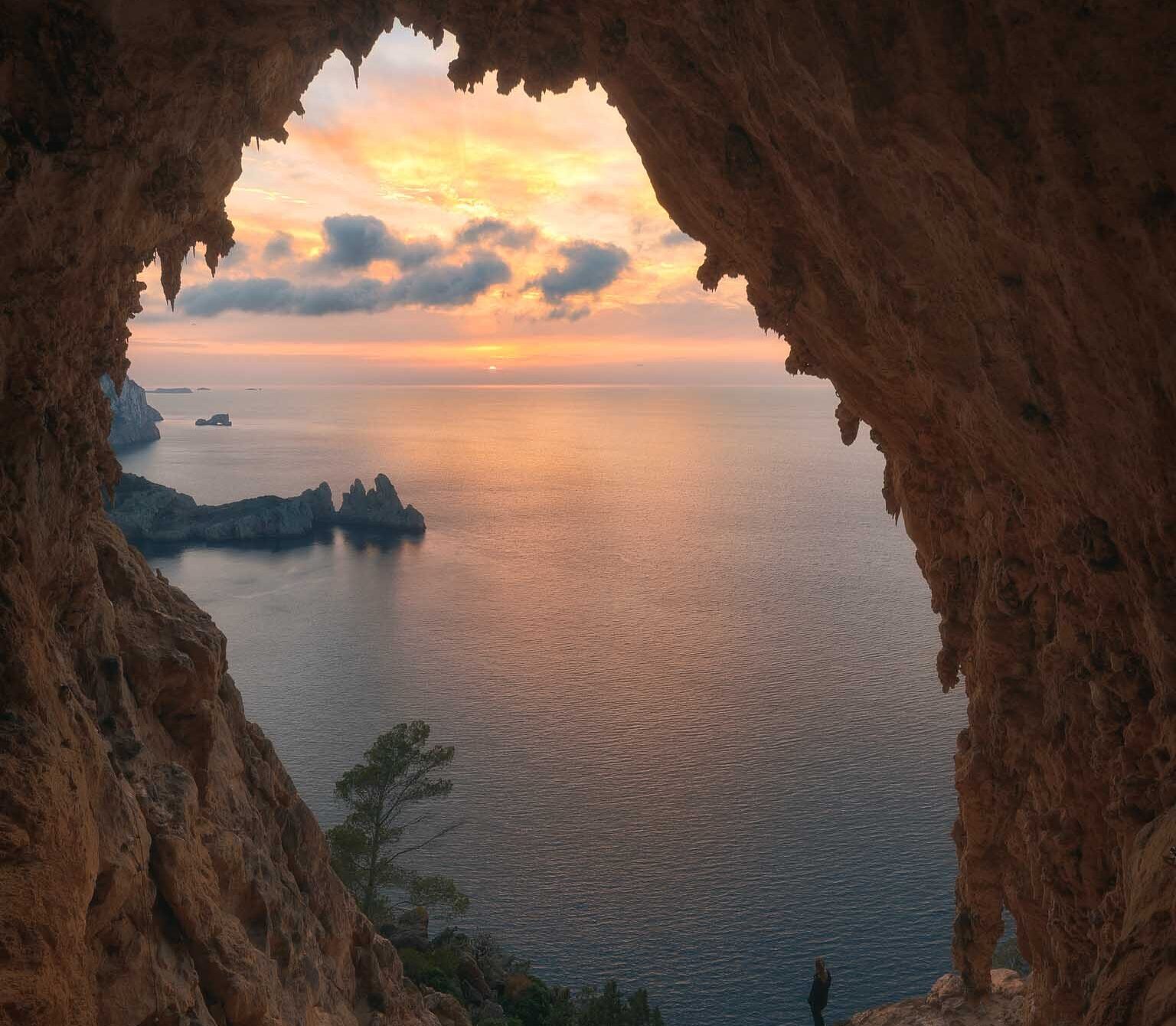 Hikers exploring massive natural stone arches and vaulted cliffs on Ibiza’s Cirque Hike, a remote trail known for its dramatic geological formations.